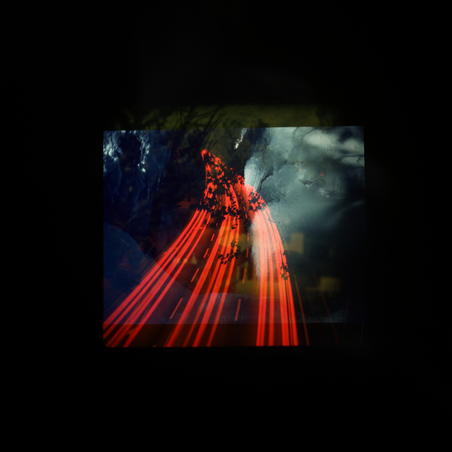 Quadratische Farbbild. In der Mitte des Bildes sieht man drei überlagerte Bilder. Nur eines der Motive ist zu erkennen: rot eingefärbte Lichtspuren von Autos auf einer dreispurigen Strasse.